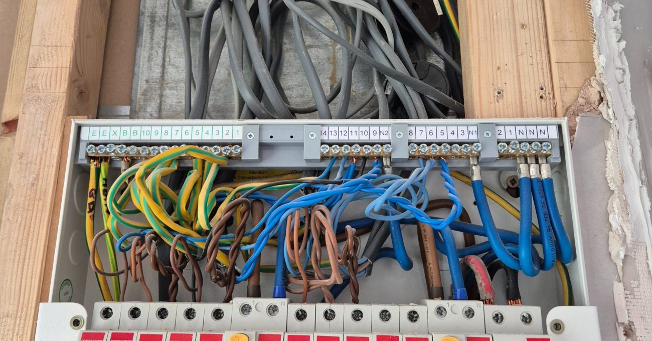Open kitchen consumer unit showing organised electrical cabling and circuit breakers during the full rewire.