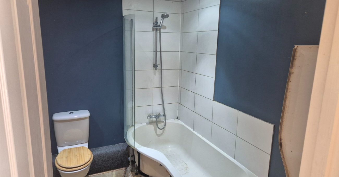 Dated bathroom in Stamford before renovation with carpet flooring and outdated fixtures
