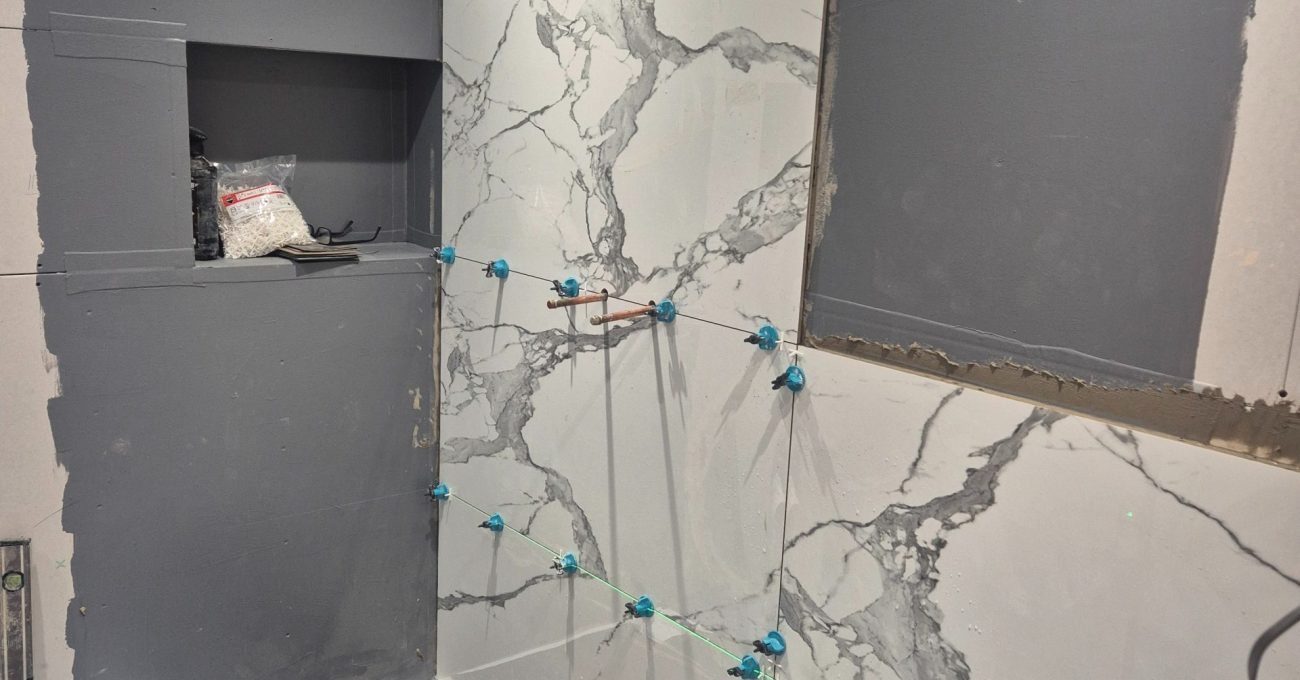 Large format wall tile installation during bathroom renovation in Stamford